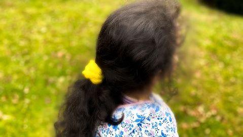 An image that shows the back of a young girl