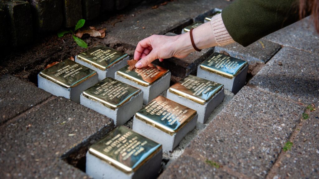 Small blocks of stone with brass on top are placed as part of a memorial on the pavement in front of houses where Jewish victims lived in Nijmegen in the Netherlands