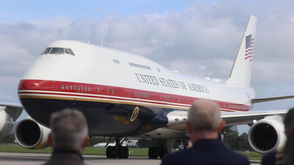 Air Force One on the tarmac in Ireland with blurred out people watching on.