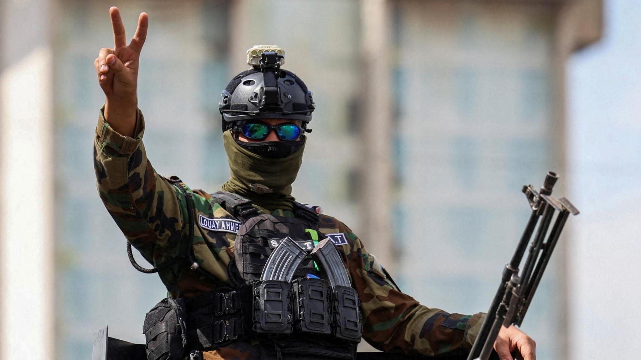 A member of the Iraqi security forces gestures as he travels in a convoy through Baghdad, Iraq (30 September 2026)