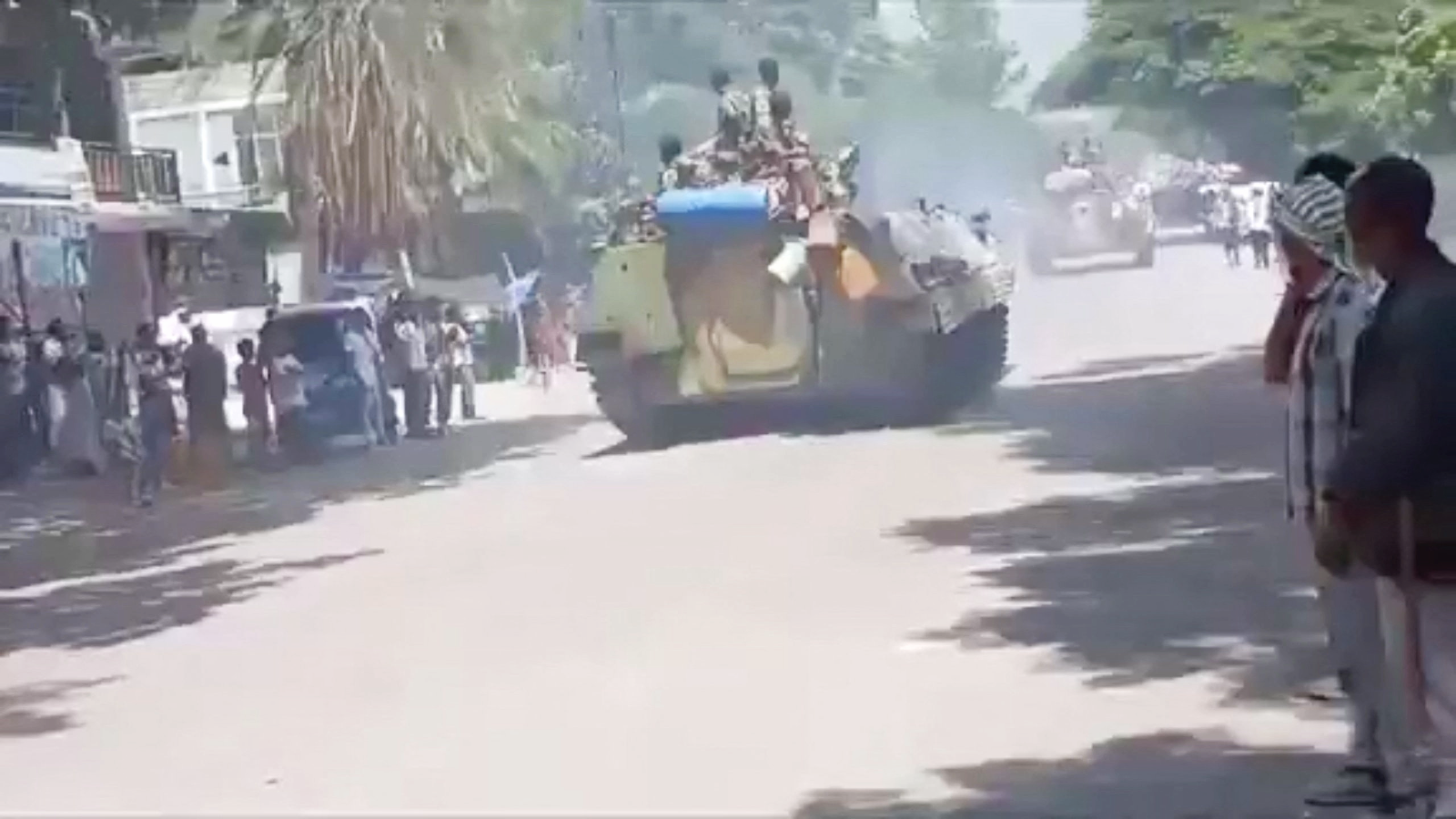 A screengrab showing people looking down a street in Alamata as tanks drive through - 28 September 2026