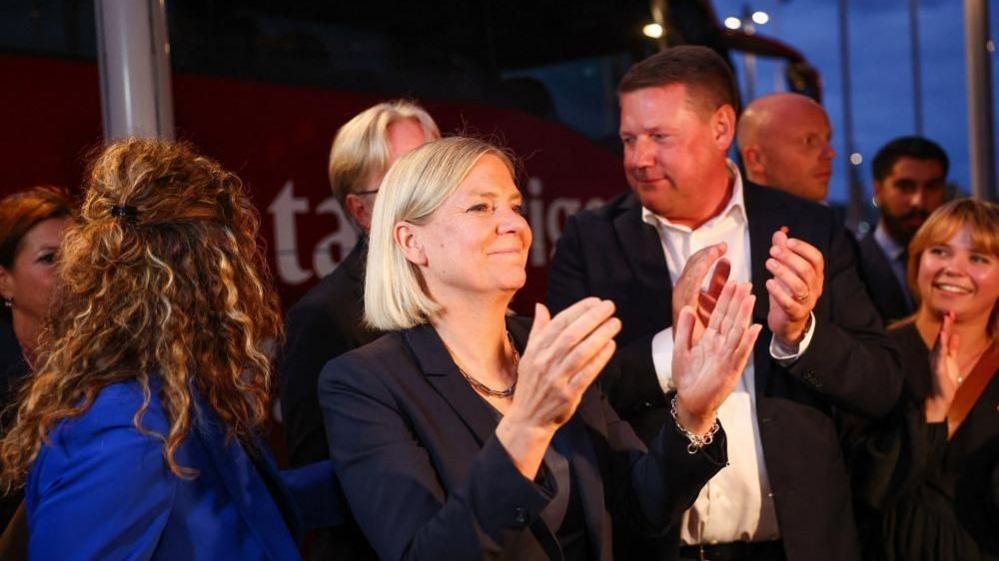Sweden's Social Democratic Party leader, Magdalena Andersson applauds as she waits with other party members for general election results