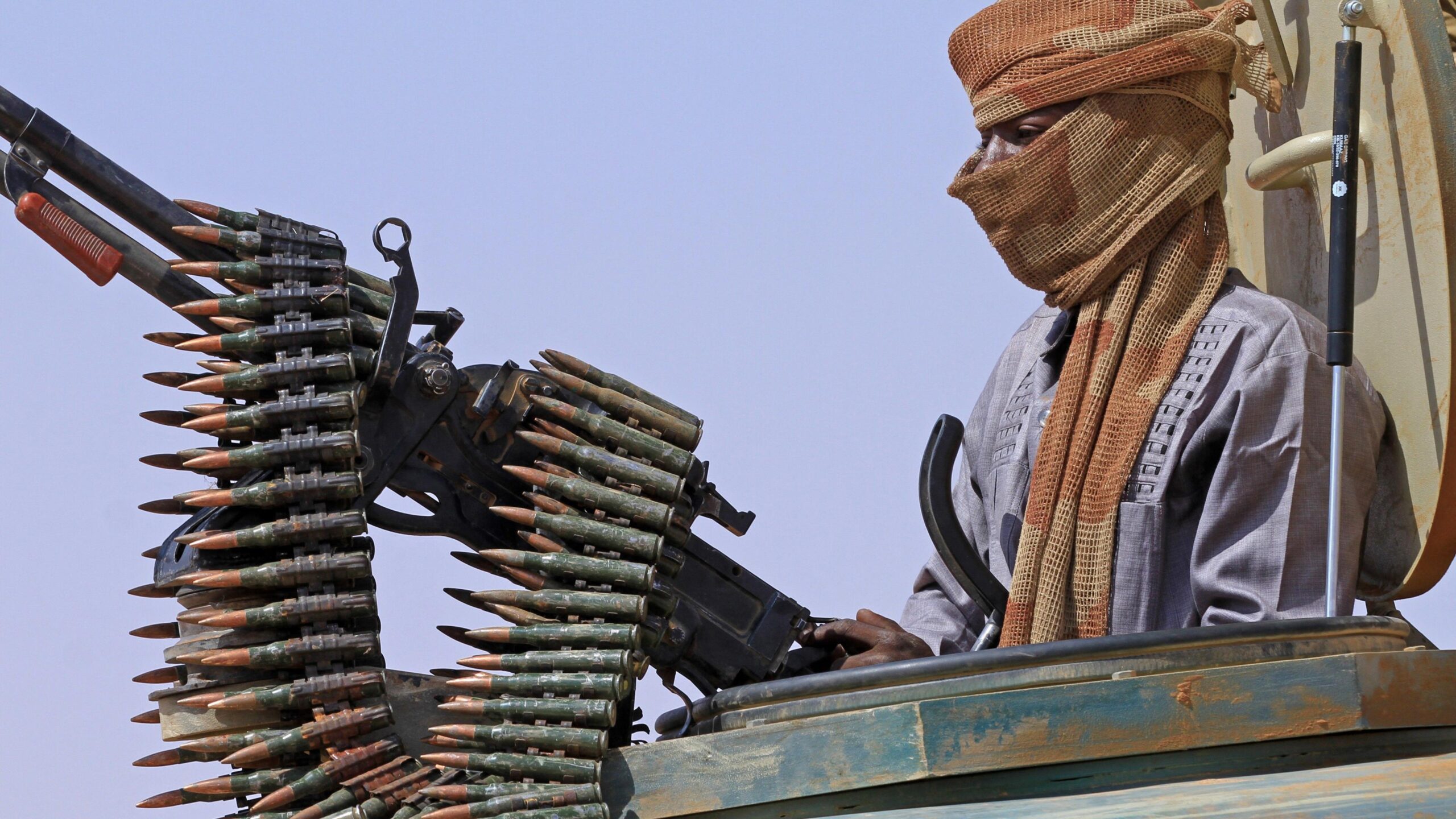 File photo of a defector from the RSF standing in an armed vehicle with a mounted gun and a chain of bullets.