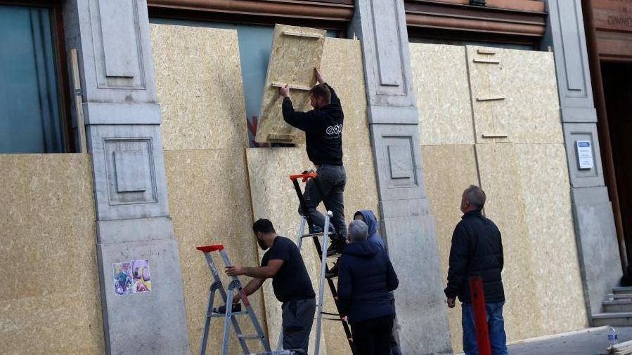A group of workers boarding up windows in Lyon
