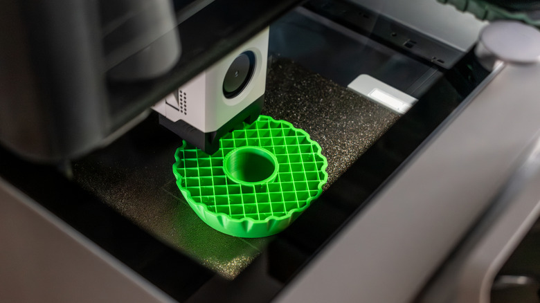 A 3D printer using green filament to print an object.